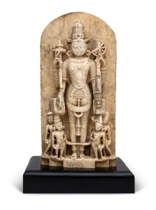 The four-armed deity standing erect, flanked by pairs of devotees, holding gada and chakra