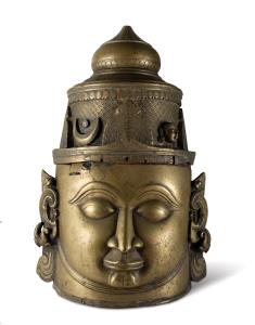 Of cylindrical form, with the face of Shiva on one side, with arched eyebrows, the domed h