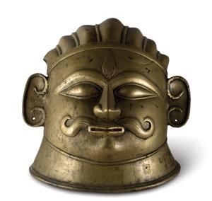 of squat form with moustachioed face of Shiva, his hair with ridged pleats held by a band 