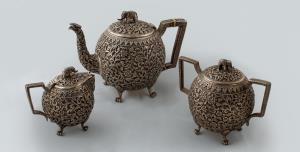 Comprising a teapot, a creamer and a sugar bowl with cover, the teapot and sugar bowl with
