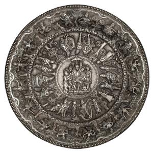 Of circular form, with a wide flared rim, the repoussé body decorated with a central round