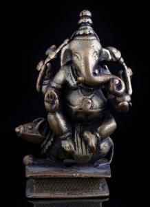 The four-armed elephant headed deity seated with legs loosely crossed on his vahana, the r
