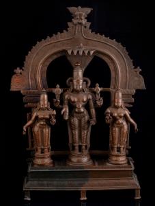 The three deities standing on a raised platform within a Prabhaveli surmounted by kirtimuk