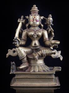 Seated in lalitasana on a raised lotus base, the four armed goddess holding damaru, Shiva 