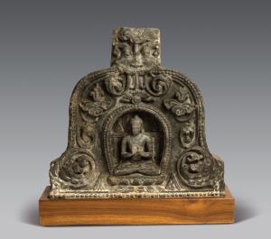 Seated within a recessed beaded gavaksha arch in padmasana on a double lotus throne, his h
