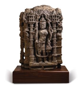 Standing in tribhanga in a columnar niche under a makaratorana, holding lotus, flywhisk an