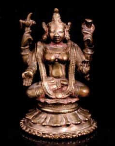 The four-armed goddess seated in padmasana on a lotus throne, her primary hands in varada 
