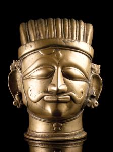 In the form of a moustachioed head of Shiva, with almond-shaped eyes and stylised third ey