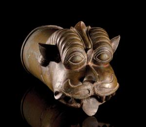 In the form of a head of a mythical lion (yali), with bulging eyes, scrolling horns and be