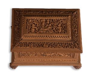 Of rectangular form, on claw feet, the exterior profusely carved in relief, the lid with a