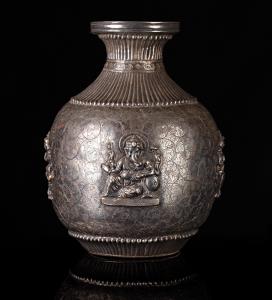 The bulbous body with waisted repousse ribbed neck and flared mouth, the sides with two im