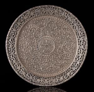 Of circular form, profusely decorated with dense scrolling foliage around a central foliat
