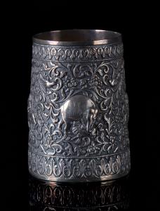 Of cylindrical form, the sides decorated in relief with fighting animals amidst densely sc
