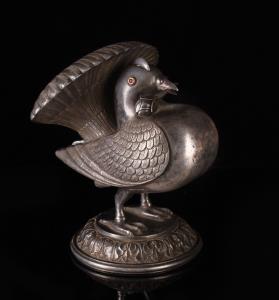 In the form of a plump Fantail pigeon with ruby-set eyes, standing on a circular acanthus 